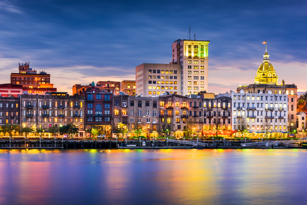 nighttime skyline of savannah georgia with colors of lights reflected on the water