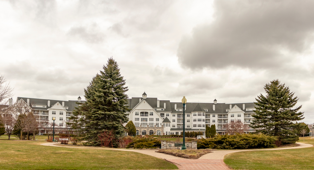 The Osthoff resort and spa with grass and trees in front of it on a grey, cloudy day