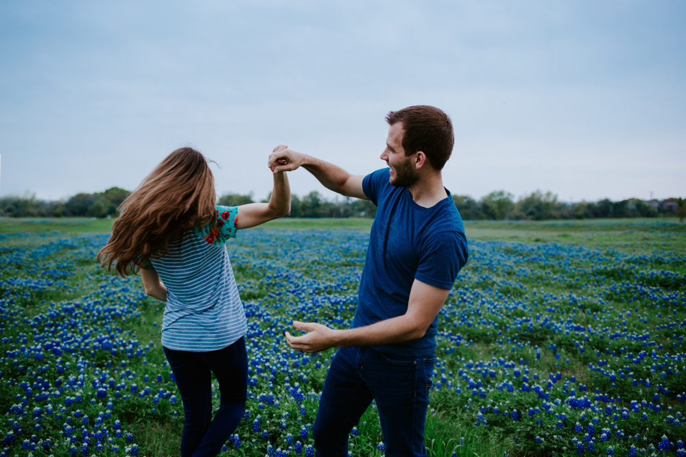 couple dancing in a bluebonnet field in Texas - image for romantic getaways in Texas